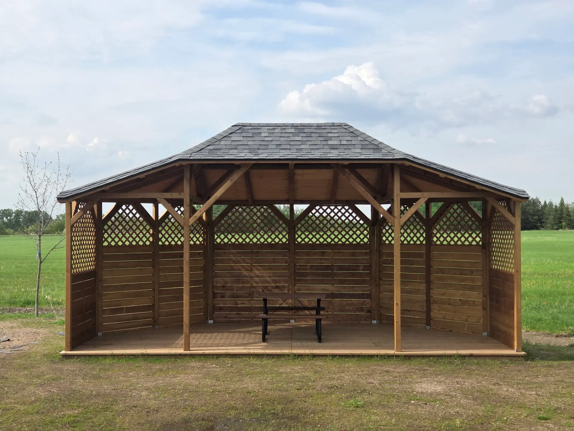 The 12 × 28 ft gazebo in daylight, with lattice sides and a cedar deck