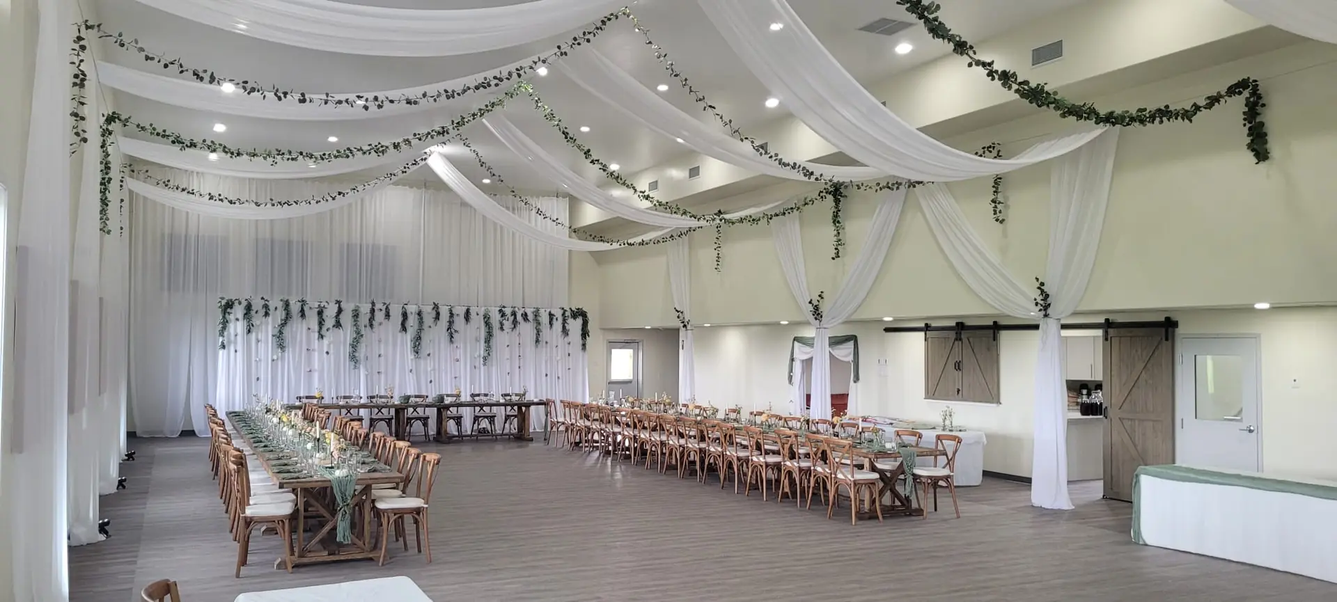 A head table at the end of the hall, dressed for a wedding by the couple's own decorator