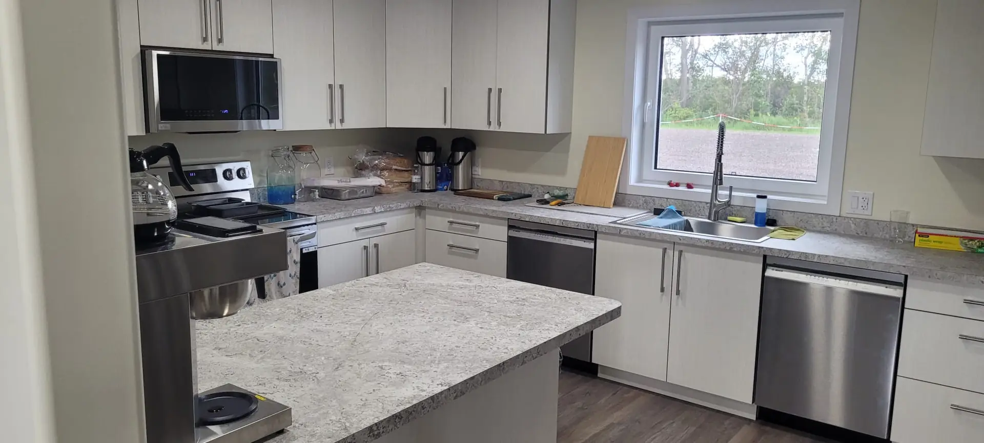The kitchen with two fridges, a stove and the commercial dishwasher